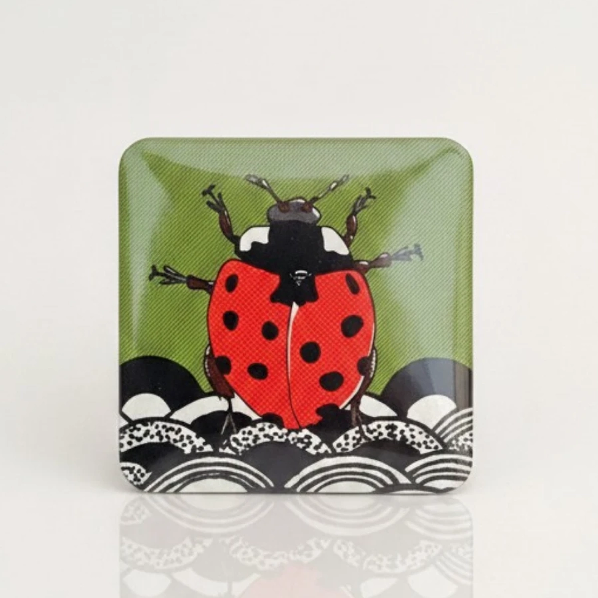 Ręcznie wykonany magnes o wymiarach 5x5 cm z ilustracją biedronki, zaprojektowany jako symbol szczęścia w autorskim, graficznym stylu.
